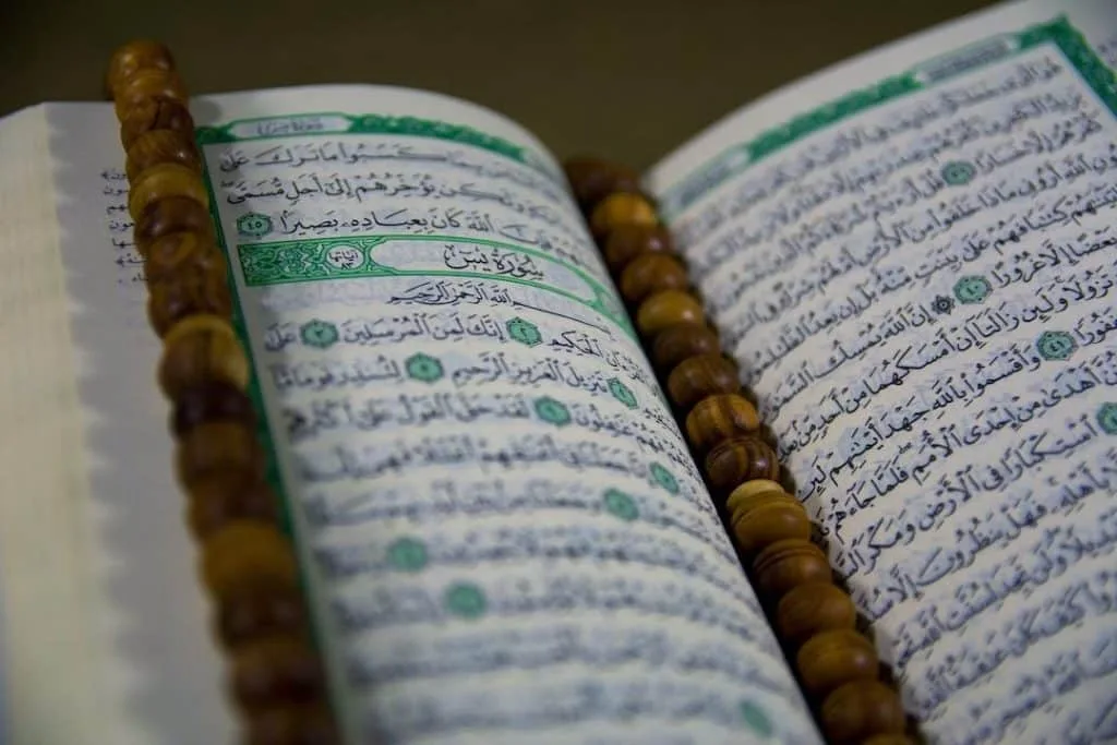 text - Closuep of Muslims Holy Book Quran Majid Closeup of Islamic Book Quran in Arabic Text and a Tasbeeh on it, tags: danmark som svar på - unsplash