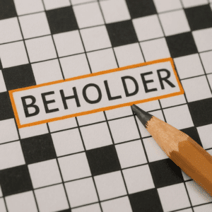 Nærbillede af krydsord med ordet ’BEHOLDER’ markeret og blyant ved siden af