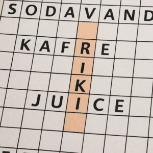 Nærbillede af krydsord med tema drik, hvor løsningsord som kaffe, sodavand og juice er fremhævet