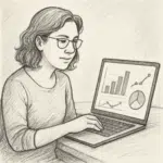 NicoleJ Krickau sidder ved skrivebord og gennemgår lønstatistik på bærbar computer med grafer.