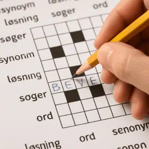 Hånd udfylder bevægelse krydsord med blyant, søger synonymer og løsningsord på papiret.