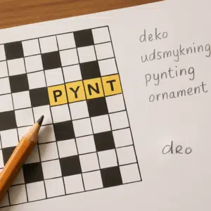 Krydsord med ordet 'pynt' fremhævet i gult, omgivet af blyant og synonymer på papir